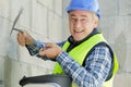 construction worker with long trowel plastering wall Royalty Free Stock Photo
