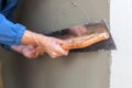 Construction worker with long trowel plastering a wall. Royalty Free Stock Photo