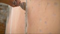 Construction worker with long trowel plastering a wall. Putty walls Royalty Free Stock Photo