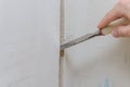 Construction worker makes a hole in the wall for electrical wiring with a chisel