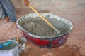 Construction worker manually mixing concrete in mixer tray