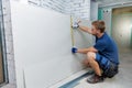 Man measuring plasterboard sheet for interior construction