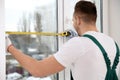 Construction worker measuring plastic window. Professional installation Royalty Free Stock Photo