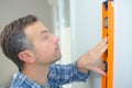 Construction worker measuring walls straightness with spirit level Royalty Free Stock Photo