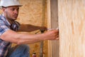 Construction Worker Measuring Width of Door Frame