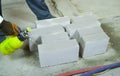Construction worker moisturing aerated concrete blocks with water sprayer Royalty Free Stock Photo