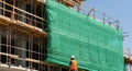 Construction worker near scaffolding with safety net at a building site Royalty Free Stock Photo