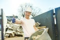 Construction Worker outside of house put old renovation material on big conteiner Royalty Free Stock Photo