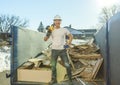 Construction Worker outside of house put old renovation material on big conteiner Royalty Free Stock Photo