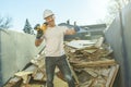 Construction Worker outside of house put old renovation material on big conteiner Royalty Free Stock Photo