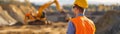 Construction Worker Overseeing Excavation at Worksite Royalty Free Stock Photo