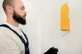 Construction worker and painter using paint roller brush painting of wall with yellow color. Royalty Free Stock Photo