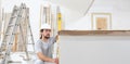 Construction worker plasterer man looks at the spirit level and checks the wall in building site of home renovation Royalty Free Stock Photo