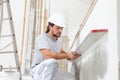 Construction worker plasterer man looks at the spirit level and checks the wall Royalty Free Stock Photo