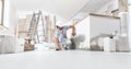 Construction worker plasterer man measuring wall with measure tape in building site of home renovation with tools and building Royalty Free Stock Photo