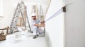 Construction worker plasterer man measuring wall with measure tape in building site of home renovation with tools and building Royalty Free Stock Photo