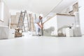 Construction worker plasterer man measuring wall with measure tape in building site of home renovation with tools and building Royalty Free Stock Photo