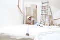 Construction worker plasterer man measuring wall with measure tape in building site of home renovation with tools and building Royalty Free Stock Photo