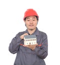 Construction worker pointing at small house model in hand Royalty Free Stock Photo
