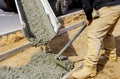 Construction worker pour cement for sidewalk in concrete works with mixer truck with wheelbarrow