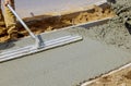 Construction worker pour cement for sidewalk in concrete works with wheelbarrow Royalty Free Stock Photo