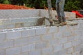 Construction worker pouring concrete into block wall at building site in afternoon Royalty Free Stock Photo