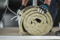 Construction Worker Preparing Roll of Mineral Wool Insulation Royalty Free Stock Photo