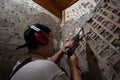 A construction worker in protective gear uses a hammer drill to remove old plaster and cement from an interior wall. A man uses a Royalty Free Stock Photo