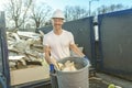 Construction Worker outside of house put old renovation material on big conteiner Royalty Free Stock Photo