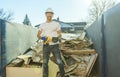 Construction Worker outside of house put old renovation material on big conteiner Royalty Free Stock Photo