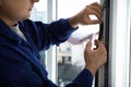 Construction worker putting sealing foam tape on window indoors, closeup Royalty Free Stock Photo