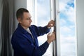 Construction worker putting sealing foam tape on window indoors Royalty Free Stock Photo