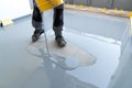Construction worker renovates balcony floor and pours watertight resin and glue before chipping and sealing Royalty Free Stock Photo