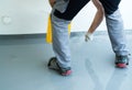 Construction worker renovates balcony floor and spreads chip floor covering on resin and glue coating before applaying water