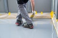 Construction worker renovates balcony floor and spreads watertight resin and glue before chipping and sealing