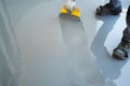 Construction worker renovates balcony floor and spreads watertight resin and glue before chipping and sealing