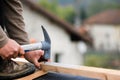 Construction worker on a renovation roof fixing a wood cleat with a hammer and nails for the infrastructure hosting the new tiles Royalty Free Stock Photo