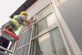 Construction worker repairing the sliding window. Open cap of adjust rail wheel Royalty Free Stock Photo