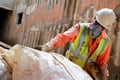 construction worker with respirator bagging asbestos waste