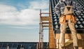 Construction Worker on a Roof Looking Over Building Site in Daylight Royalty Free Stock Photo