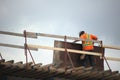 Construction worker on roof metal beams man holding plywood Royalty Free Stock Photo