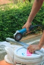 Construction worker`s hands cutting aluminium frame with angle grinder. Royalty Free Stock Photo