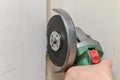 Construction worker sawing a hole in the wall for electrical wiring with a grinder Royalty Free Stock Photo