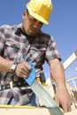 Construction Worker Sawing At Site