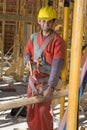 Construction Worker Saws Board Smiling - Vertical