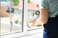 Construction worker sealing window with caulk