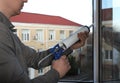 Construction worker sealing window with caulk indoors, closeup Royalty Free Stock Photo