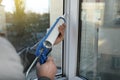 Construction worker sealing window with caulk indoors, closeup Royalty Free Stock Photo