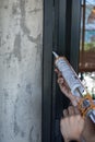 Construction worker sealing window with caulk indoors Royalty Free Stock Photo