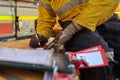 Construction worker setting and writing his name on personnel isolation red danger tag which is attached with personal lock